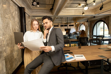 Two young professionals working in the office and looking involved