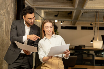 Two young professionals working in the office and looking involved