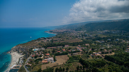 Fototapeta premium Tropea From Above – Coastal Town, Beach Life, and Lush Landscape
