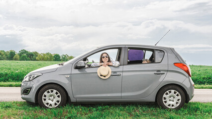 Family in car. Man woman child traveling. Summer adventure road smile.