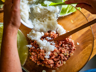 Cooking stuffed cabbages on wooden table - polish cuisine golabki