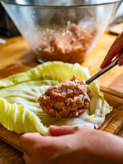 Cooking stuffed cabbages on wooden table - polish cuisine golabki
