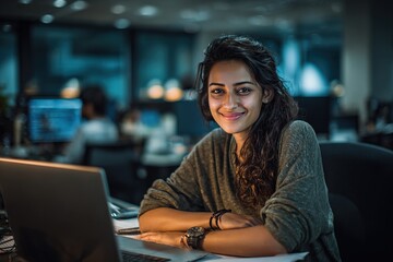 Portrait young it specialist latin hispanic business lady working on laptop pc sitting at desk in modern office smiling at camera. Middle eastern indian woman using computer technology for work online