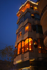 Charming building with warm, inviting lights at dusk in Lahore, Pakistan. Urban evening scene.