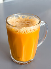 Teh tarik served in a clear glass mug, Malaysia’s iconic pulled milk tea with frothy top and rich, sweet aroma.