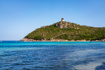 Naklejka premium Porto Giunco beach with ancient Nuraghe tower dominating the hill in Villasimius, Sardinia, Italy
