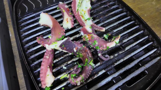 Man hands Flip tentacles while Cooking octopus on a barbecue grill. seafood texture