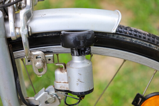 A close-up of a bicycle's front wheel showcases the dynamo and braking system, highlighting technical details. This photograph is ideal for images related to bicycle repair, maintenance, active recrea