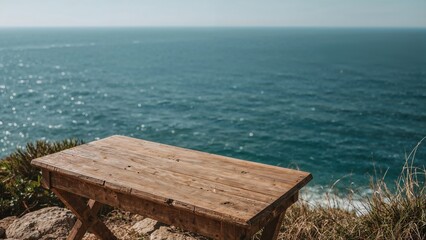 Rustic wooden table overlooking ocean cliffside with clear blue sky and gentle waves