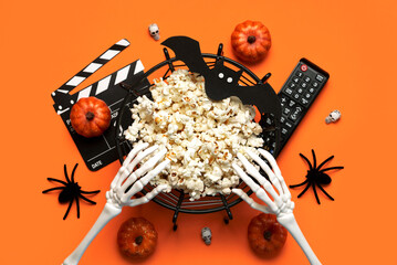Halloween movies concept. Top view of bowl of popcorn, movie clapperboard,Halloween party decoration and television remote control. Halloween concept background