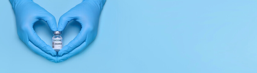 Doctor's gloved hands forming a heart shape while holding a Lenacapavir vaccine vial on a blue...