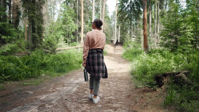 Curious woman traveler filming and photographing by smartphone amazing nature. Female tourist hiking in reserve park in summer trip, exploring and discovering new location for tourists, travel blogger