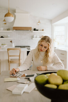 Designer examining tile samples at light wood table