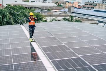 Worker inspects solar panels on rooftop in urban setting during daylight
