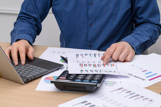 An office worker conducting commercial operations on paper enters data into the IT system, data digitization, modern development