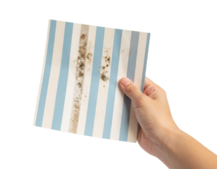 A hand holds a blue and white striped tile with visible dirt and stains on its surface.