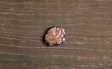 Rare medieval copper coin of India on wooden table