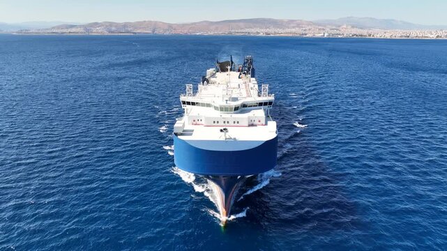 Aerial drone video of UECC LNG powered RoRo (Roll on-off) car transportation vessel cruising Saronic gulf deep blue sea, Attica, Greece