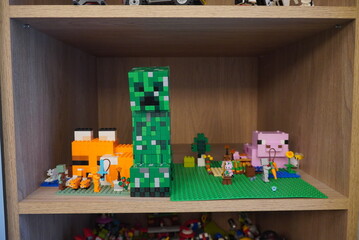 Fototapeta premium Lego Minecraft Figures and Landscape on a Wooden Shelf