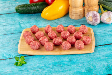 Raw beef meatballs over board