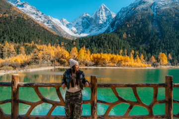 Bipenggou national park Young asian tourist with the Beautiful snow mountains in autumn, Chengdu ,Sichuan in China.