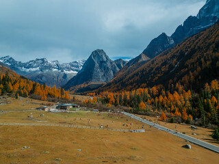 Aerial view of  Couple tourist relaxing  at  Mount Siguniang national park with the Beautiful  snow mountains in autumn, Chengdu ,Sichuan in China.