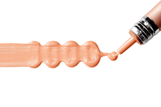 Peachy cosmetic cream being dispensed.  A tube dispenses a light peach-toned cream, flowing in a line with textured bumps