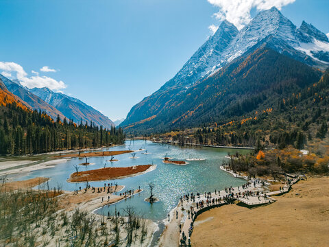 Aerial view of  Couple tourist relaxing  at  Mount Siguniang national park with the Beautiful  snow mountains in autumn, Chengdu ,Sichuan in China.