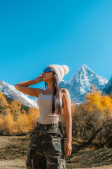 Naklejka premium Bipenggou national park Young asian tourist with the Beautiful snow mountains in autumn, Chengdu ,Sichuan in China.