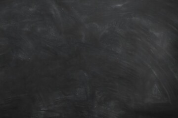 Smudged black chalkboard texture with dusty marks and dark matte surface for education, school, or blackboard design background