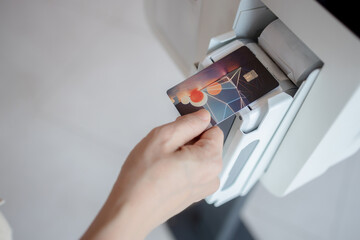 Close up image of a woman holding a creditcard and a payment transaction to bank payment terminal