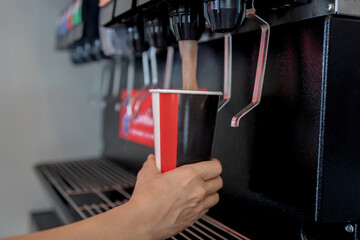 Close-up of a hand squeezing a soda from a vending machine