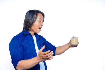 Asian men hold a glass of milk coffee with an expression of surprise with an open mouth