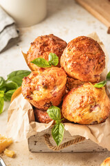 Savory egg muffins with bazil, ham and cheese in white wooden box on kitchen table background close up. Healthy and quick morning breakfast