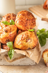 Savory egg muffins with bazil, ham and cheese in white wooden box on kitchen table background close up. Healthy and quick morning breakfast