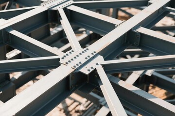 Geometric arrangement of industrial steel beams at a construction site, bathed in soft natural light.