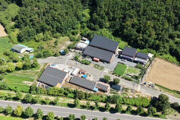 Aerial View of Rooftop Solar Panel Installation on Rural Business and Residential Buildings –...
