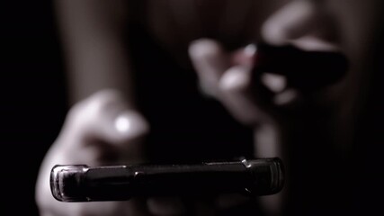 Close-up of a woman's hands scrolling through social media feed on a smartphone in the dark. Perfect for technology, communication, and social media related projects.