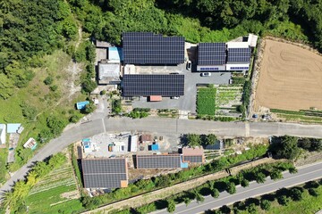 Aerial View of Rooftop Solar Panel Installation on Rural Business and Residential Buildings –...
