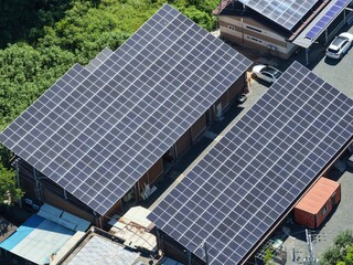 Aerial View of Rooftop Solar Panel Installation on Rural Business and Residential Buildings –...