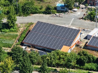 Aerial View of Rooftop Solar Panel Installation on Rural Business and Residential Buildings –...