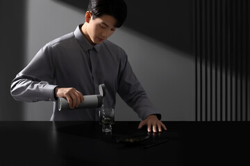 Young Asian man preparing tea in minimalistic setting.