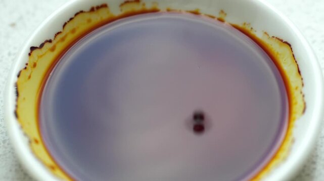 Dripping iodine at the white dish. Slow motion