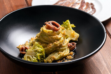 Linguine con acciughe, broccoli e briciole di pane croccante, pasta italiana 