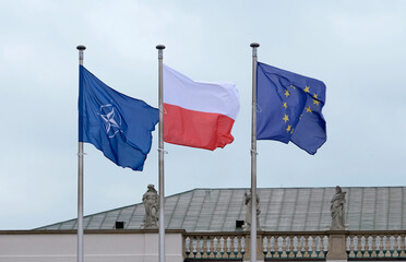 Flags of NATO, the EU and Poland waving in the wind next to each other