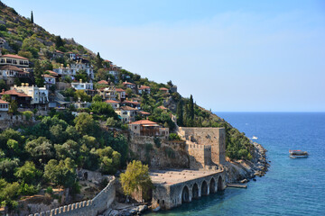 Naklejka premium Coastal Fortress and Cliffside Village Under a Clear Sky copy space