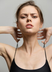 Confident young woman adjusting her black outfit, displaying strength and determination, with...
