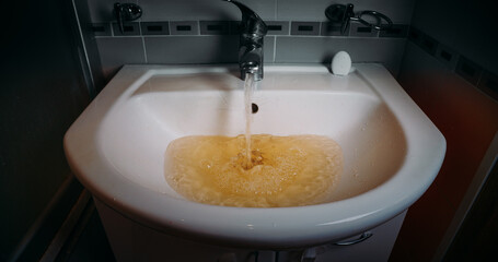 Basin overflowing with yellow tinted water