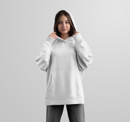Mockup of a white long oversized hoodie on a girl in a hood, front view, isolated on a background.