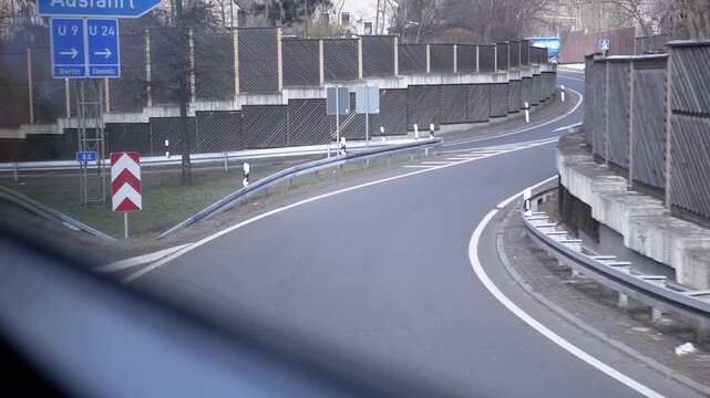 View from a moving vehicle of a highway exit with road signs indicating directions to Berlin and Chemnitz. Suitable for travel, navigation, and German autobahn videos.